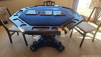 Front view of the octagonal poker table showing blue felt playing surface and wood frame