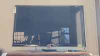 Front view of 46-inch Samsung flat screen TV showing reflective screen and black bezel with stand.