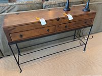Front view of wooden top, two drawers and metal base