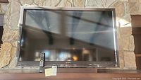 Front view of the Sony 52-inch flatscreen TV with the remote standing on its base.