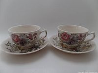 Photo showing two Johnson Brothers tea cups with matching handles decorated with the Sheraton floral pattern.