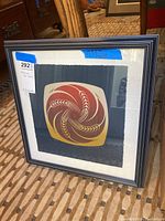 Overall view of framed print showing black frame and mat surrounding abstract print