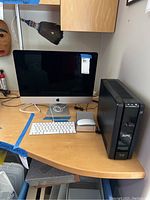 Full desk setup showing iMac, keyboard, mouse, and APC UPS unit