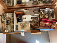 Overhead view of multiple jewelry trays on dresser surface