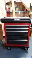 Front view of closed red and black Craftsman tool chest on caster wheels