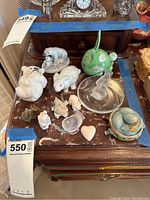 Various porcelain and glass animal figurines and trinket boxes arranged on wooden table