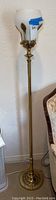 Full height view of 62" tall brass metal floor lamp with inverted glass globe shade