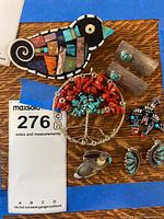 Overview of all earrings and pins laid on wood surface