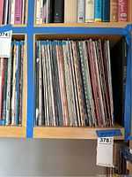 Shelf of assorted vinyl records showing multiple LP jackets