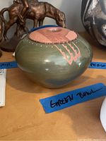 Front view of rounded pottery bowl showing olive green glaze and exposed terracotta accents with a "Green Bowl" label nearby