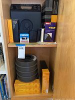 Photo of vintage slide projector and included Kodak boxes, carousels, and Carson LumiLoupe box on a wooden shelf