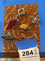 Overall view of six sterling silver jewellery pieces on wood