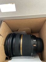 Lens body inside original box packaging showing mount end and focus/zoom rings.