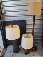 Three lamps displayed next to each other on the ground showing size differences and lamp bases.