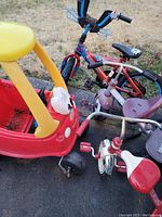 Photo showing all items: one yellow and red toddler push car and three toddler bikes.