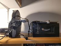 Side view shows disk sander with rounded sanding disk and power cord.