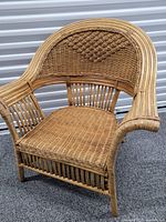 Full view of woven wicker chair showing arched back and armrests
