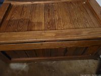 Photos showing the top and inside of a large wooden chest with natural wood finish and minor scratches.