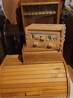 Wooden decorative box with village scene carving, wooden roll-top bread box, and two wooden boxes stacked together