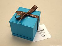 Closed turquoise Birks presentation box tied with brown ribbon