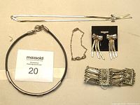 Photo of all jewelry laid out on a surface including necklace, choker, bracelets, and earrings