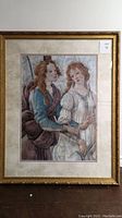 Front view of matted and framed print showing two women in historical dress, gold-tone ornate frame, beige and pink matting.