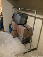 Full view of the pipe rack set against a wall with some boxes and bins on and around it.