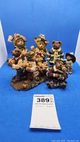 Photo showing entire group of bear figurines including three Boyd's Bears and two additional ceramic bear figurines on blue background