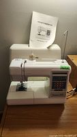 Front view of Kenmore 150 sewing machine with owner's workbook on top