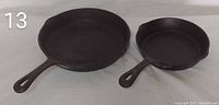 Two cast iron skillets side by side, showing the different sizes.
