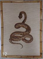 Full front view of rattlesnake artwork showing the coiled rattlesnake centered in the frame with beige background and bamboo style wooden frame.