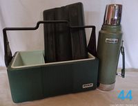 Green Stanley two-section lunchbox with handle, showing size and removable trays inside.