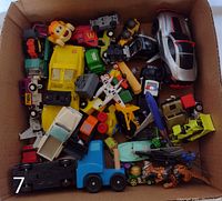 Top-down photo showing a variety of toy cars and vehicles of different sizes and colors packed together.