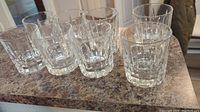 Eight pressed glass double old fashioned glasses arranged on a countertop