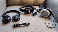Three pairs of wired on-ear headphones displayed on a gray surface.