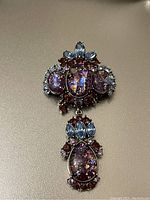 Photo of the full brooch showing upper and lower sections with purple amethyst cabochons and blue navette stones