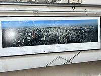 Frontal view of the panoramic framed print showing Tokyo cityscape with Tokyo Tower under clear sky and the print title text below.