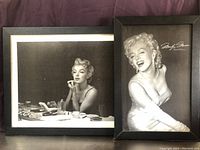 Two framed Marilyn Monroe black and white photographs by Sam Shaw. One image shows Monroe seated at a vanity, the other smiling and wearing gloves with signature overlay.
