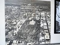 Aerial view showing the Sacramento Capitol Building centered with surrounding cityscape and greenery in black and white.