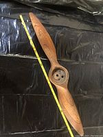Full view of wooden propeller with tape measure beside it showing length approximately 32 inches.