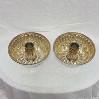 Top view of two vintage bundt style metal baking pans showing fluted sides and central tube.