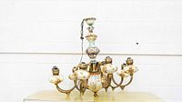 Front angled view of the chandelier highlighting porcelain and brass components.