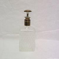 Full view of the clear glass decanter showing the diamond-cut pattern and metal stopper.