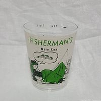 Front view of the Fisherman's Nite Cap glass, showing cartoon fisherman wrapped in a blanket and the text.