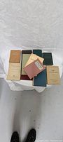 Photo of 11 assorted German books in various cover colors, arranged on a white cloth.