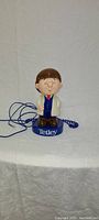 Front view of Tetley Tea phone with figurine and coiled cord visible.