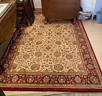 Full view of the area rug between furniture showing the overall floral design.