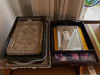 Top view of a stack of various serving trays showing glass, wood, and metal trays.