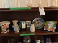 Shelf display showing a collection of vases, a collector plate with dogs, and a small framed print. Includes Italian marked vase.