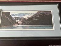Framed print showing Lake Louise landscape by Ralph Temple with mountains and lake in natural colors.